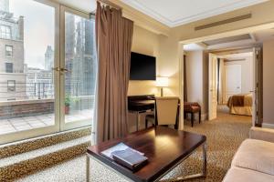 纽约奥米伯沙尔广场酒店的配有一张书桌和大窗户的酒店客房