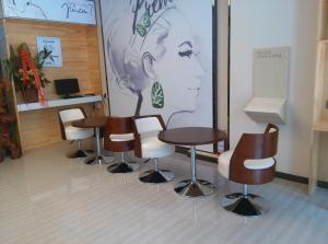 哈密7天优品·哈密市政府店的一间设有桌椅和壁画的等候室