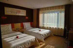 四平7天优品·公主岭市火车站店的酒店客房设有两张床和窗户。