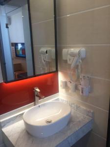 吴忠7天优品·吴忠万达广场店的浴室设有白色水槽和镜子
