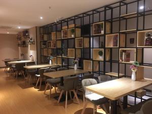 綦江区7天优品.重庆綦江区政府店的餐厅设有桌椅和一堵书墙