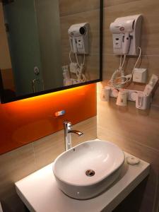 重庆7天优品重庆江北国际机场店的浴室设有白色水槽和镜子
