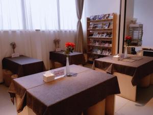 重庆7天优品重庆两江新区鱼复工业园鱼嘴店的一间房间,配有两张带鲜花的桌子