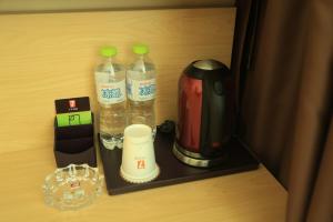 蓬莱7天优品烟台蓬莱新汽车站店的配有两瓶水和搅拌机的橱柜