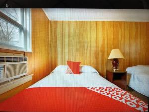内普顿市Monmouth OYO的一间卧室配有一张带红白毯子的床