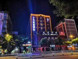 赣州7天优品·赣州汽车站店的城市的建筑物,晚上有灯光标志