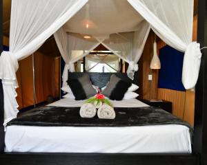 卢甘维尔海龟湾酒店 的卧室配有白色的床和2个枕头