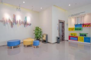 景洪市7天酒店·西双版纳嘎洒机场客运南站店的配有桌椅的房间和艺术墙