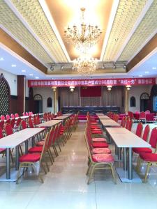 乌鲁木齐7天酒店·乌鲁木齐米东中路神华矿务局店的宴会厅配有桌子和红色椅子