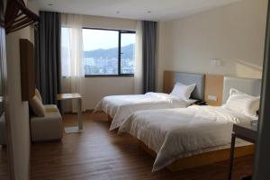 7天酒店·赣州会昌昌寿店的酒店客房设有两张床和窗户。