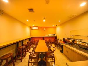 沈阳7天酒店·沈阳火车站太原街店的餐厅拥有黄色的墙壁和木桌及椅子
