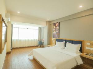 三亚7天酒店三亚亚龙湾景区店的卧室设有一张白色大床和一扇窗户。
