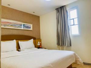 南宁7天连锁酒店南宁七星路店的卧室设有一张白色大床和一扇窗户。