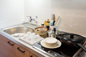 东京My Home in Tokyo的厨房配有水槽和炉灶及餐具