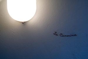 科莫卡娜瑞纳住宿加早餐酒店 的墙上的灯,上面写着照相机