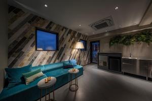 川崎slash kawasaki的一间带蓝色沙发的客厅和一间厨房