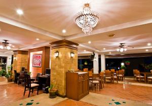 芭东海滩Jiraporn Hill Resort的餐厅配有吊灯和桌椅