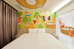 台中市台中逢甲图乐文旅的一间卧室配有一张床,墙上挂着绘画作品