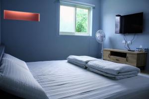 小琉球岛自由空间的蓝色卧室配有床和平面电视