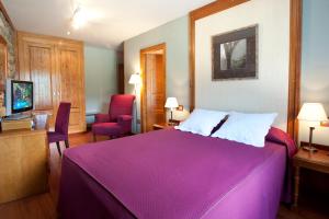 卡斯特洪德索斯蒂亚莫酒店的一间卧室配有一张大紫色的床和一把椅子