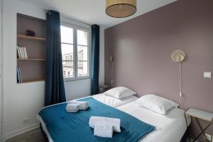 圣马洛Cap à l'Ouest by Cocoonr的卧室配有带2条毛巾的窗户,位于床上