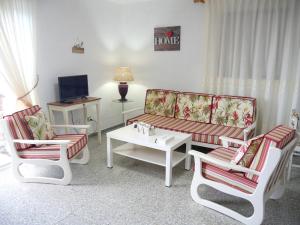 EchedoAPARTAMENTO LOS CACTUS的客厅配有沙发、椅子和桌子