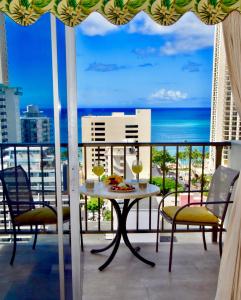 檀香山珍妮的菠萝小屋公寓式酒店的一个带桌椅的海景阳台