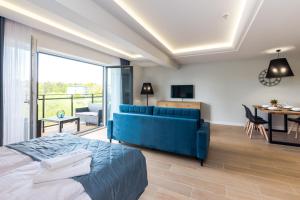 达洛科Apartamenty N7的一间带蓝色沙发的卧室和一间客厅