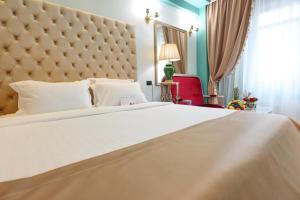 布加勒斯特腓尼基大酒店的卧室配有一张大白色的床和大床头板