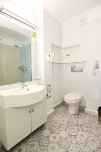 布加勒斯特腓尼基大酒店的白色的浴室设有水槽和卫生间。