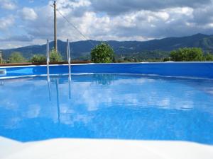 韦扎诺利古雷卡萨瓦坎泽里洛度假屋的一个大型蓝色游泳池,后面是群山