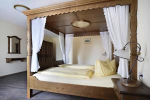 萨勒河畔瑙姆堡Hotel und Restaurant Rittergut Kreipitzsch的卧室配有带白色窗帘的天蓬床