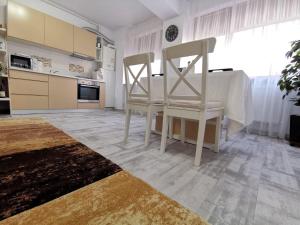 康斯坦察Cappuccino Apartment-Brilliant Apartments的厨房配有2把白色椅子和桌子