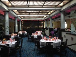 查茨沃斯DoubleTree by Hilton Chatsworth的用餐室配有桌椅和粉红色玫瑰