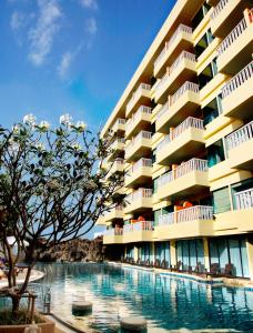 芭东海滩Palmyra Patong Resort Phuket - SHA Extra Plus的大楼前设有游泳池的酒店