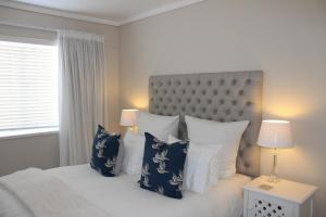 克尼斯纳Waterfront - Knysna Quays Accommodation的一间卧室配有一张带蓝色和白色枕头的床