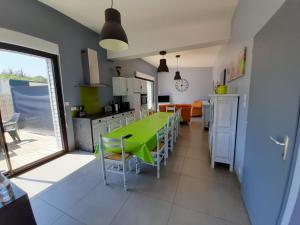 圣让-德蒙CLOS DE L'OCEAN 2 - maison 3 chambres à 300 m de la plage的厨房以及带绿色桌椅的用餐室。