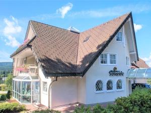 施卢赫湖Villa Sunside Appartements und Ferienwohnungen Schluchsee的白色房子,有石板屋顶