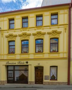 Benešov nad PloučnicíPenzion Růže的黄色的建筑,上面有花园办公室