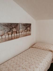 皮耶特拉卡梅拉La Casetta in Montagna的卧室配有一张床,墙上挂有两张照片