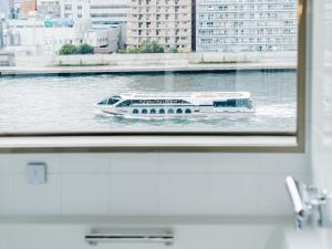 东京The Share Hotels Lyuro Tokyo Kiyosumi的船在水中穿过窗户