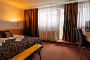 OutokumpuHotelliravintola Kumpu的配有一张床、一张书桌和一扇窗户的酒店客房
