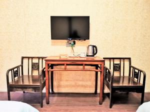 绍兴绍兴老台门鲁迅故里国际青年旅舍的一张桌子、两把椅子和墙上的电视