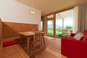 阿皮亚诺苏拉斯特拉达Weingut Stuck的客厅配有木桌和红色沙发