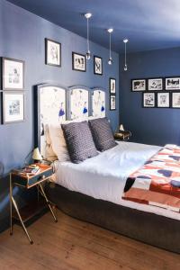 索姆河畔的圣瓦列里拉菲姆科特迪瓦酒店的一间卧室配有一张带蓝色墙壁的大床
