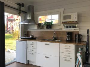 SmedjebackenLottas stuga的厨房配有白色橱柜和水槽