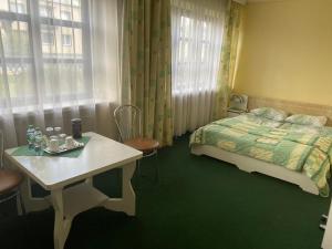 Tytuvėnai萨马纳汽车旅馆的卧室配有一张床和一张桌子及椅子