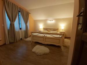 普雷代亚尔Vila Piscul Ursului的一间卧室配有一张带两盏灯的床和一扇窗户。