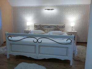 普雷代亚尔Vila Piscul Ursului的一间卧室配有白色床和2个床头柜