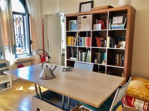 米兰La Casa sul Ballatoio - Isola Milano的一间设有桌子和书架的房间